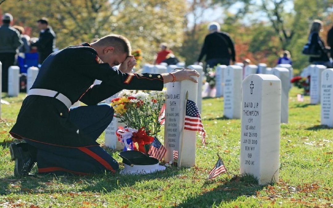 Soldier Kneeling at Grave Honoring Sacrifices for Fourth of July